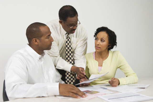 A black financial advisor meeting with African American clients to discuss their financial plans for retirement.